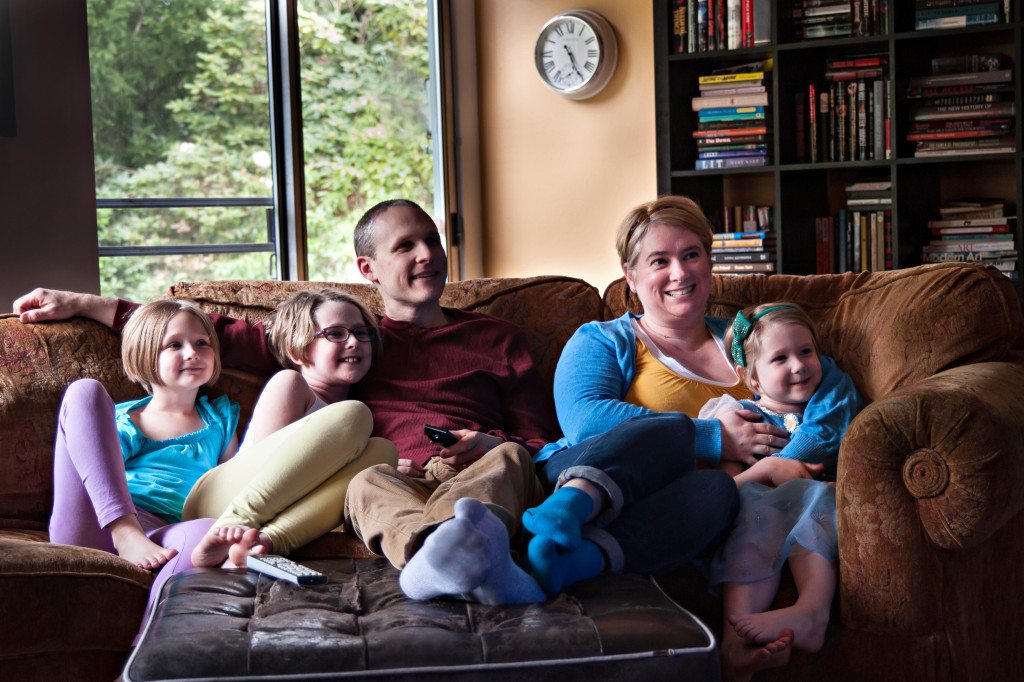 Family enjoying a movie on the couch