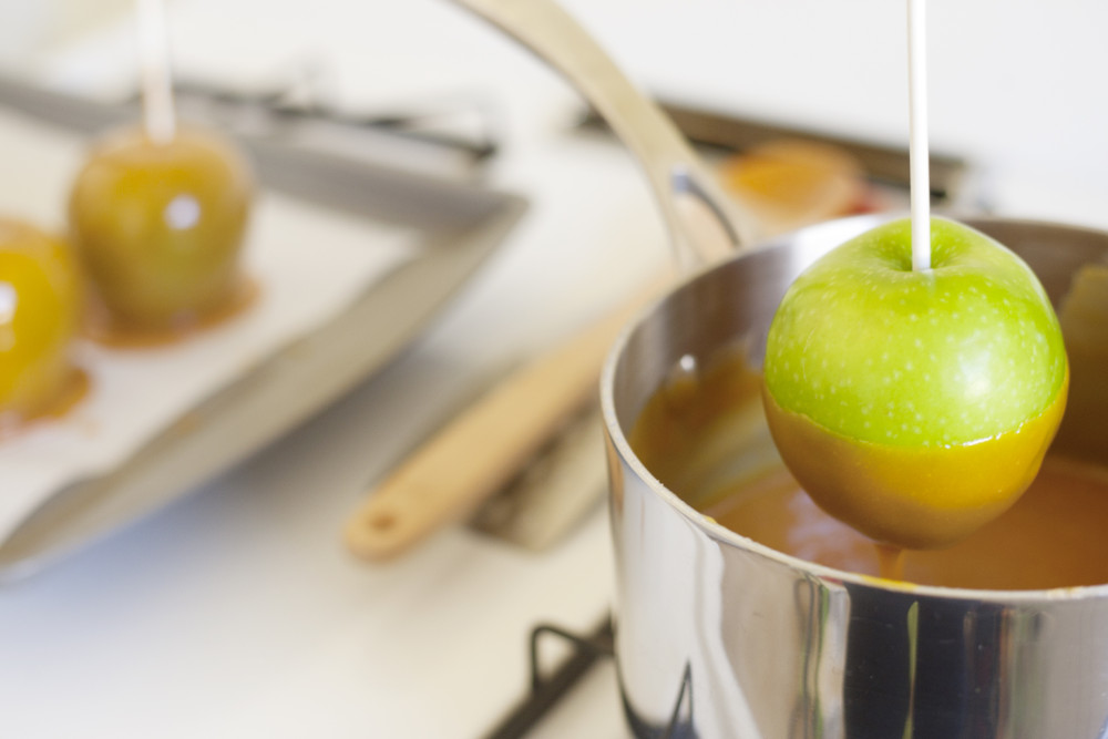 Green apple dipped in caramel from a pot