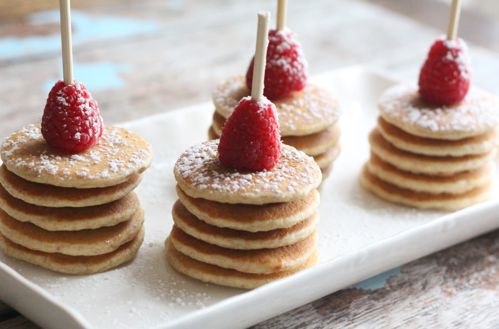 miniature pancakes with strawberries and powdered sugar