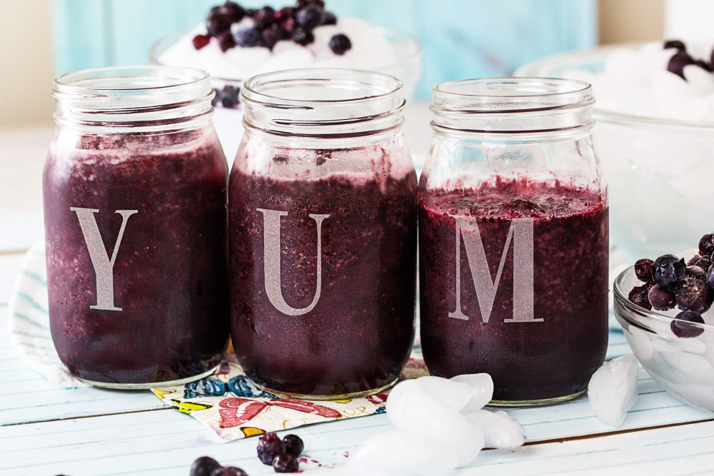 fresh juice smoothies with mixed berries in mason jar glass