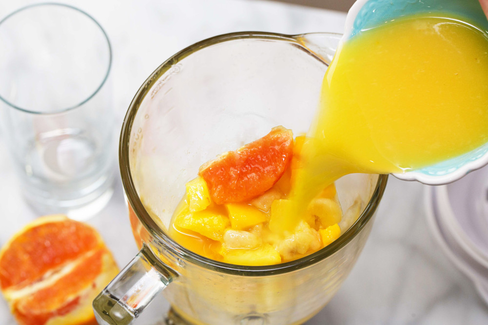 pouring juice into pitcher carafe