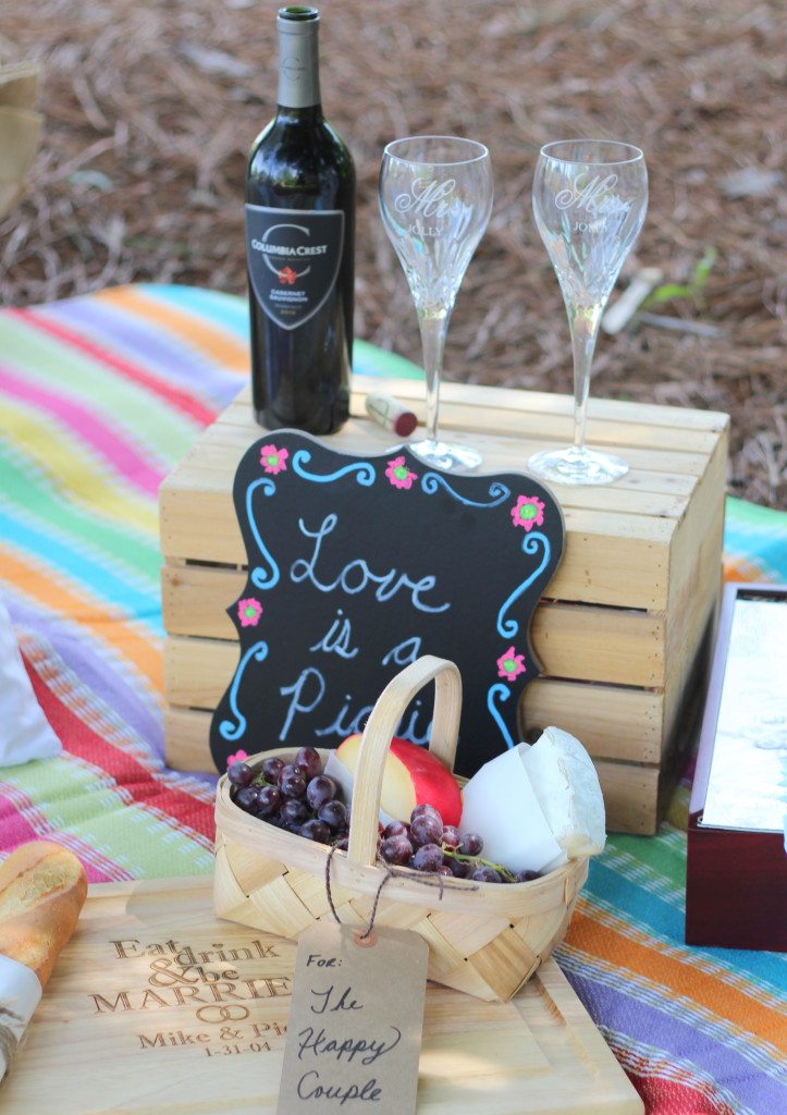 wine glasses on a box cutting board with cheese fruit and bread chalkboard