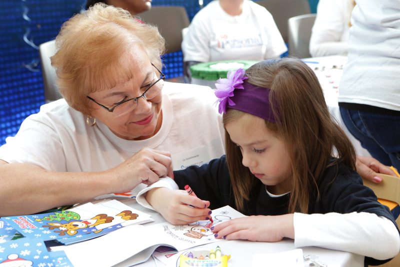 Personal Creations employee Liz Golebiowski colors and crafts with Zoey Girard. Photo by Jean Marc Giboux/AP Images for Personal Creations.