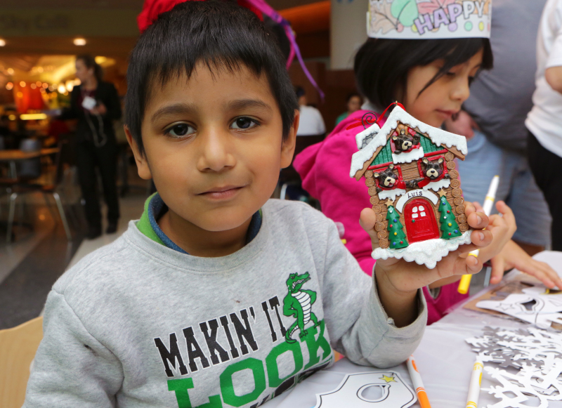 Luis shows off his personalized ornament while partaking in some arts and crafts activities. Photo by Jean Marc Giboux/AP Images for Personal Creations.
