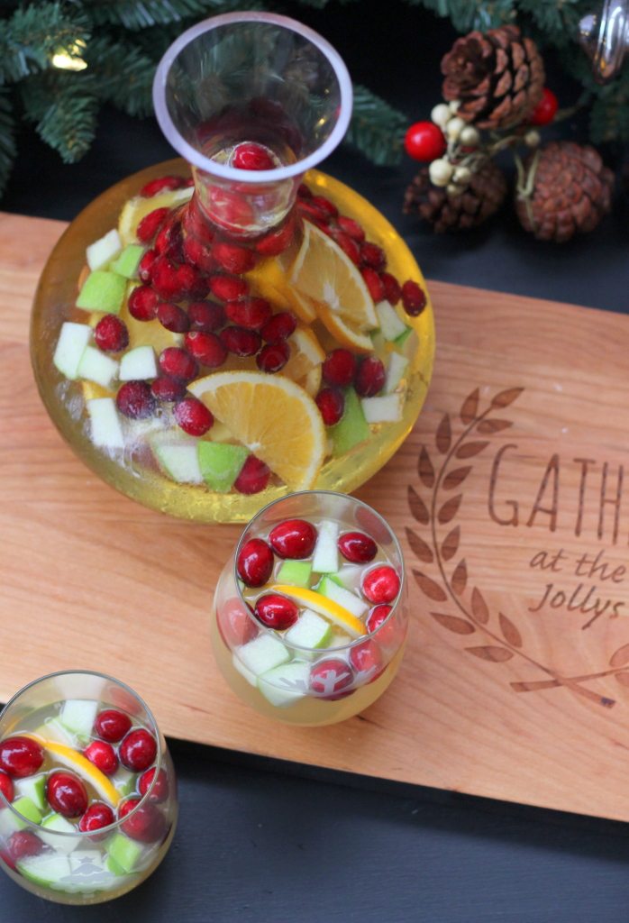 holiday sangria with apples and oranges in glasses and pitcher