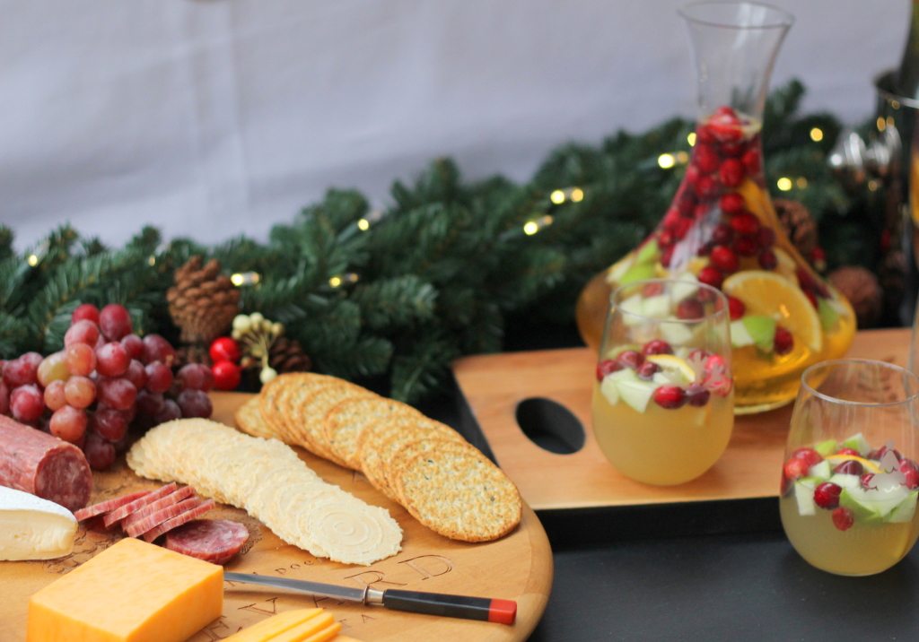 holiday sangria with apples and oranges with crackers cheese and salami