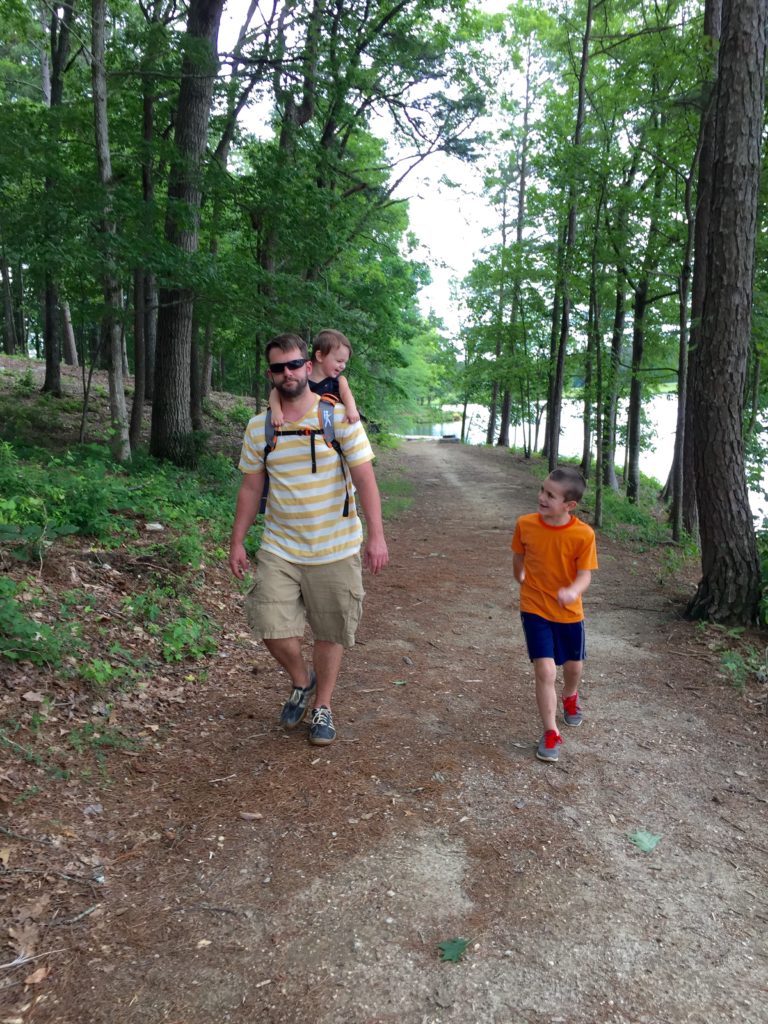 father and children on a walk in the woods