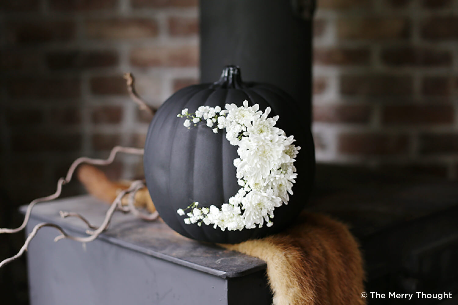pumpkin painted black with white flowers in shape of moon