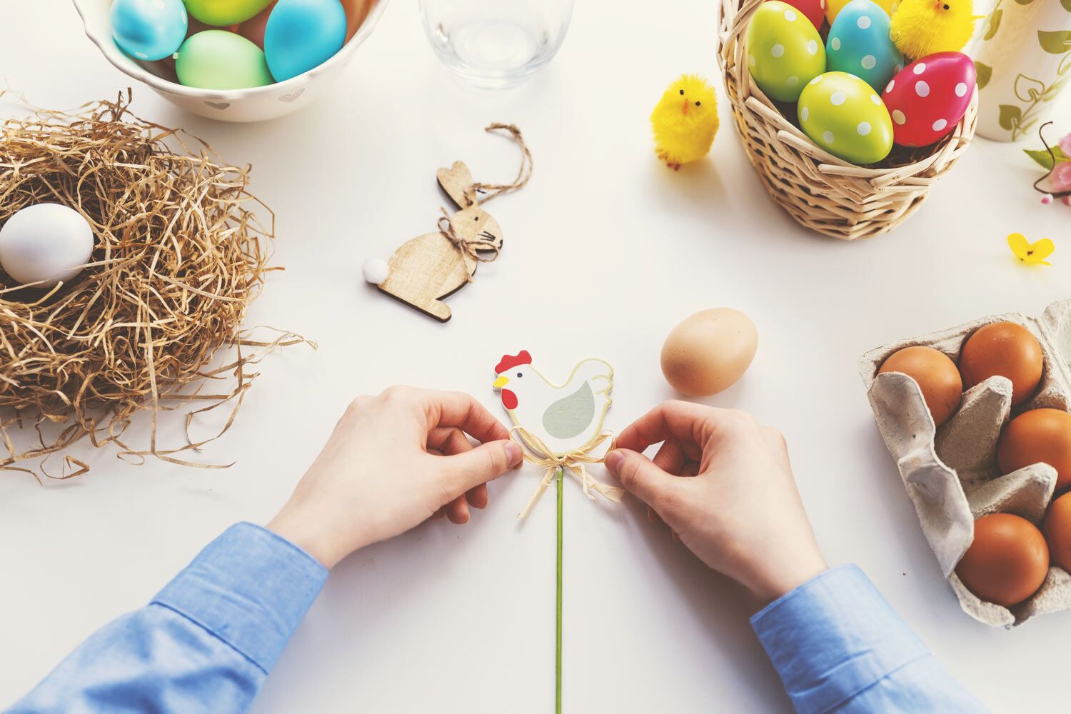 hands making a chicken easter craft with easter eggs 